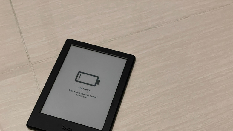 A Kindle screen displaying a large low battery warning icon with an exclamation mark.
