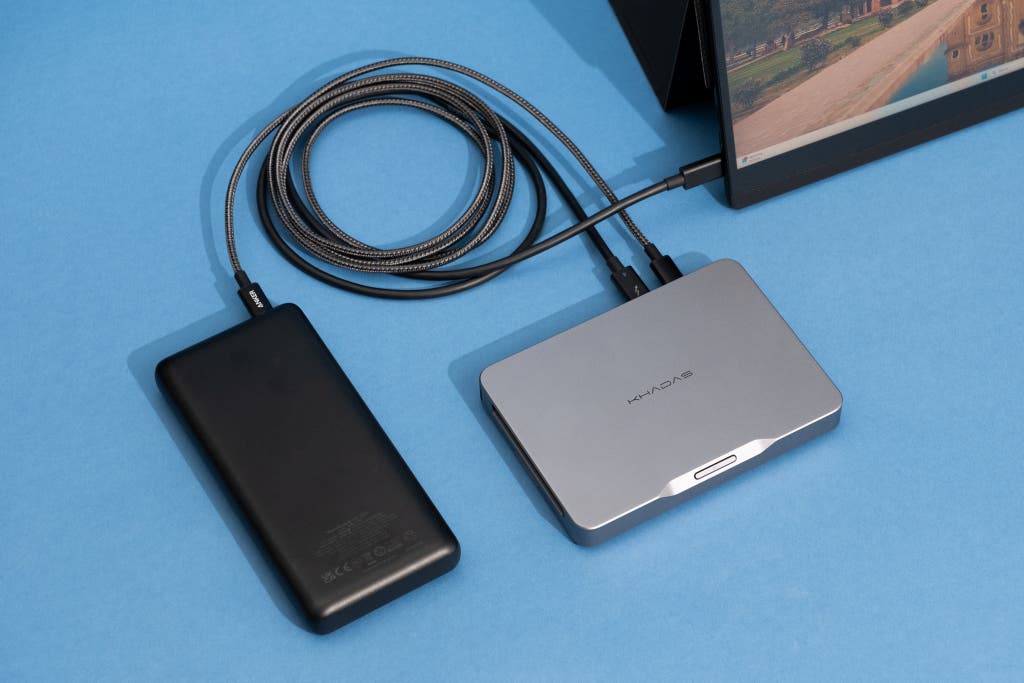 A Khadas Mind mini PC being used portably with a battery dock and external monitor.