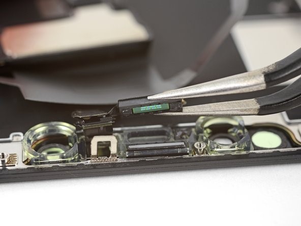 The internal components and logic board of an iPhone 14 surrounded by precision repair tools.