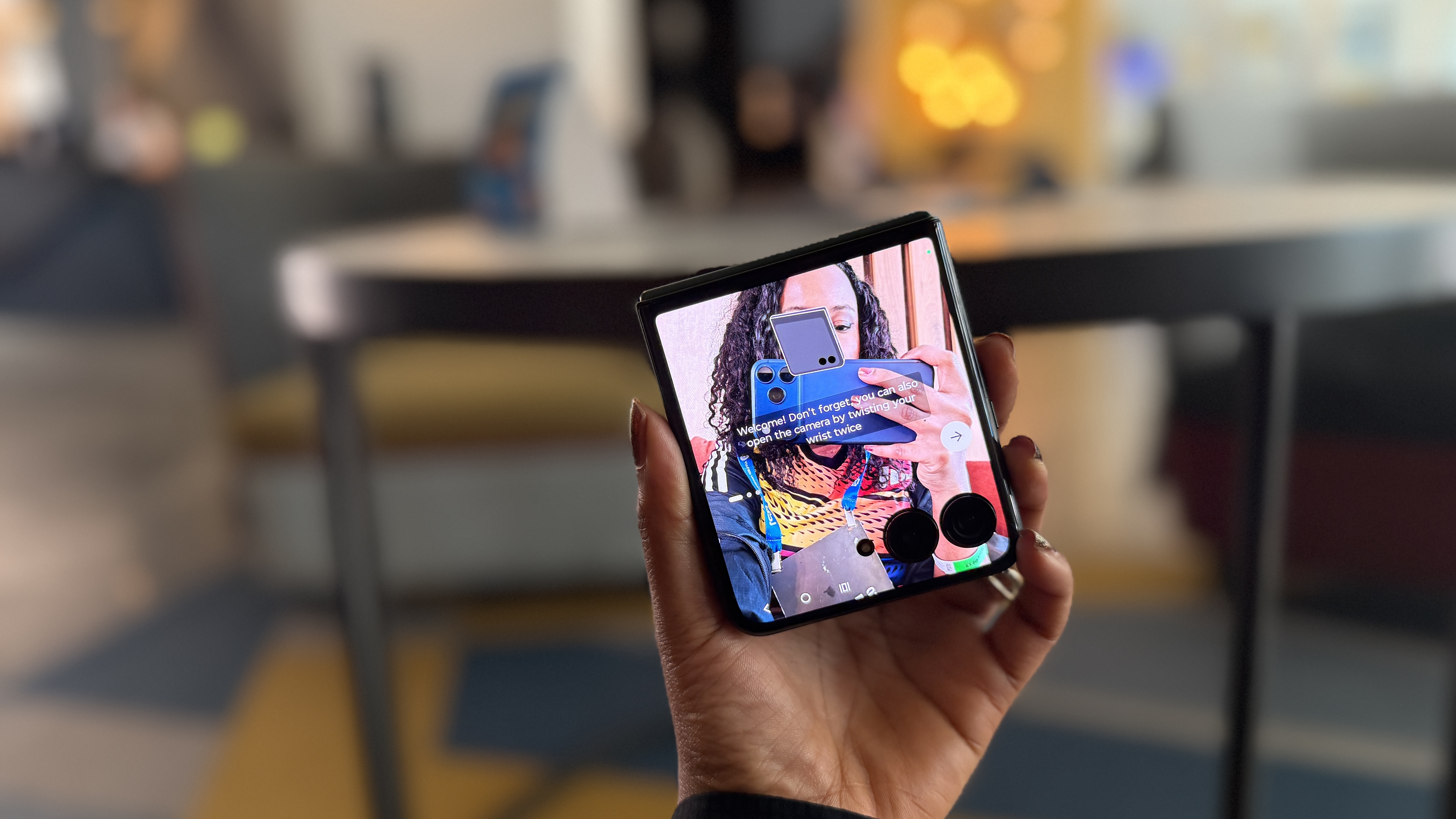A woman using the Motorola Razr+ cover display as a viewfinder to take a selfie