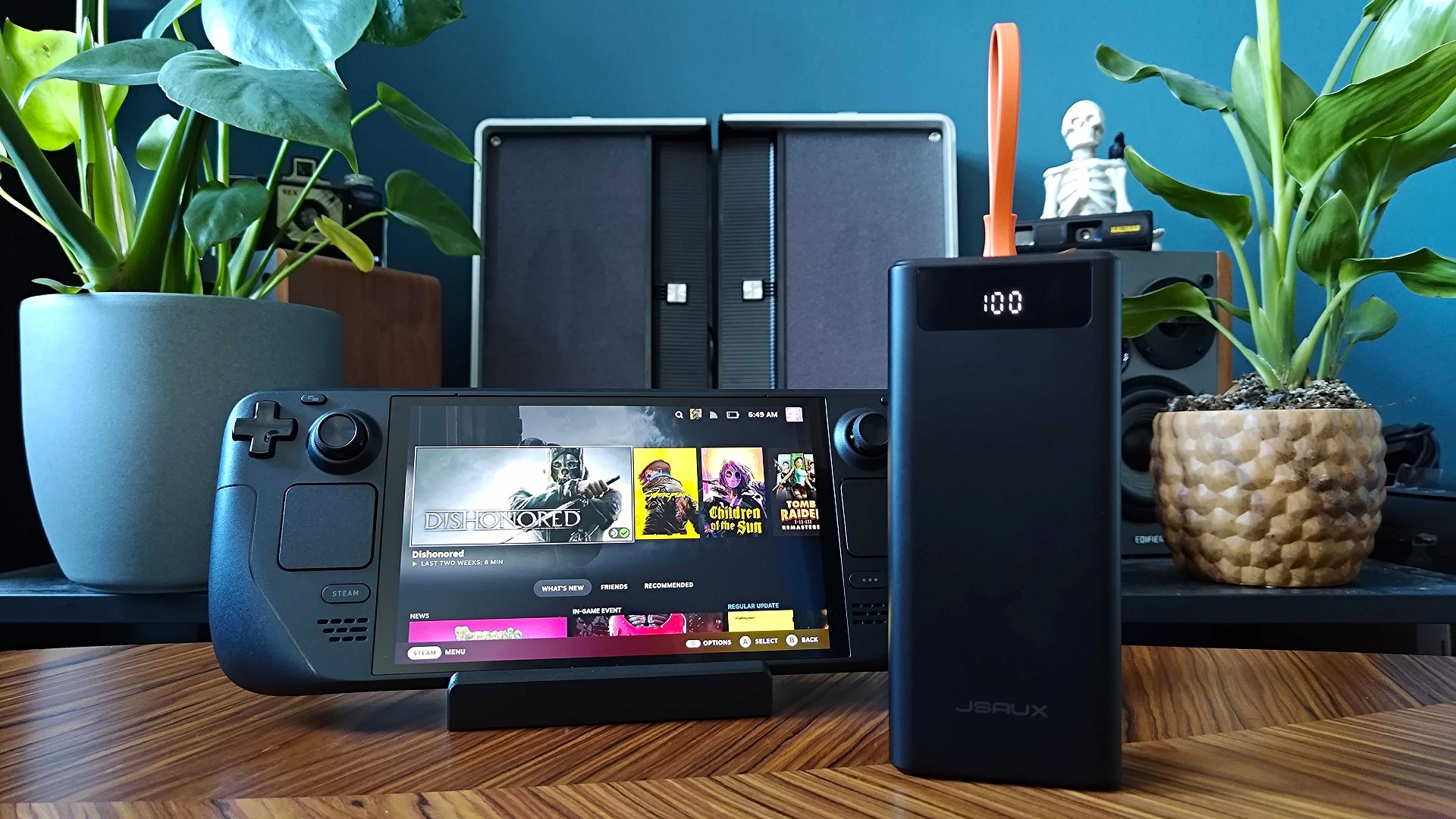 A large Jsaux 65W 20000mAh power bank placed next to a Steam Deck OLED model.