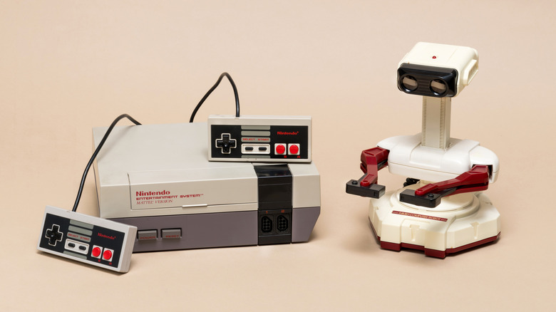 The Robotic Operating Buddy (R.O.B.) standing next to an original Nintendo Entertainment System (NES).
