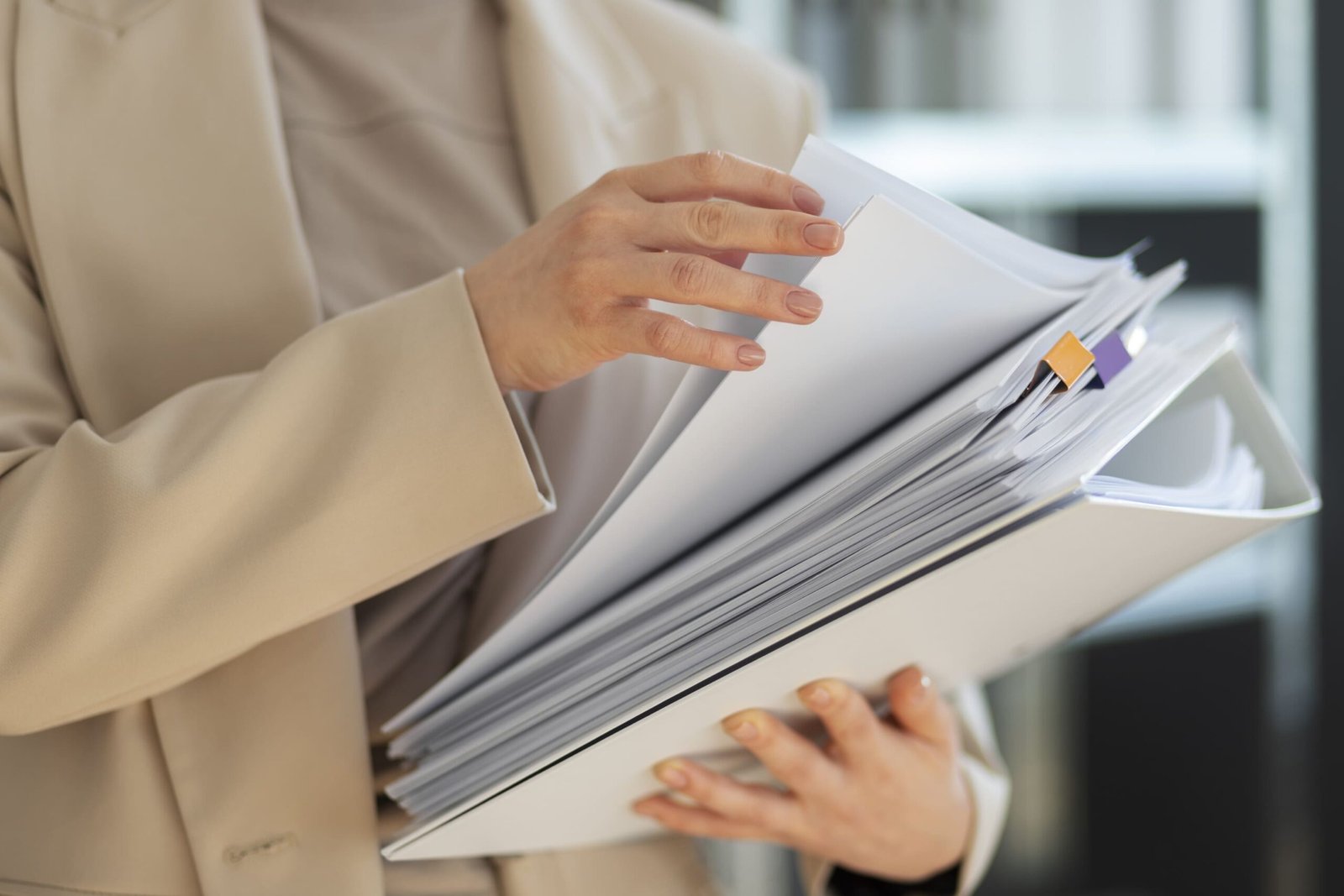 A professional organizing a binder filled with solar installation technical documentation.