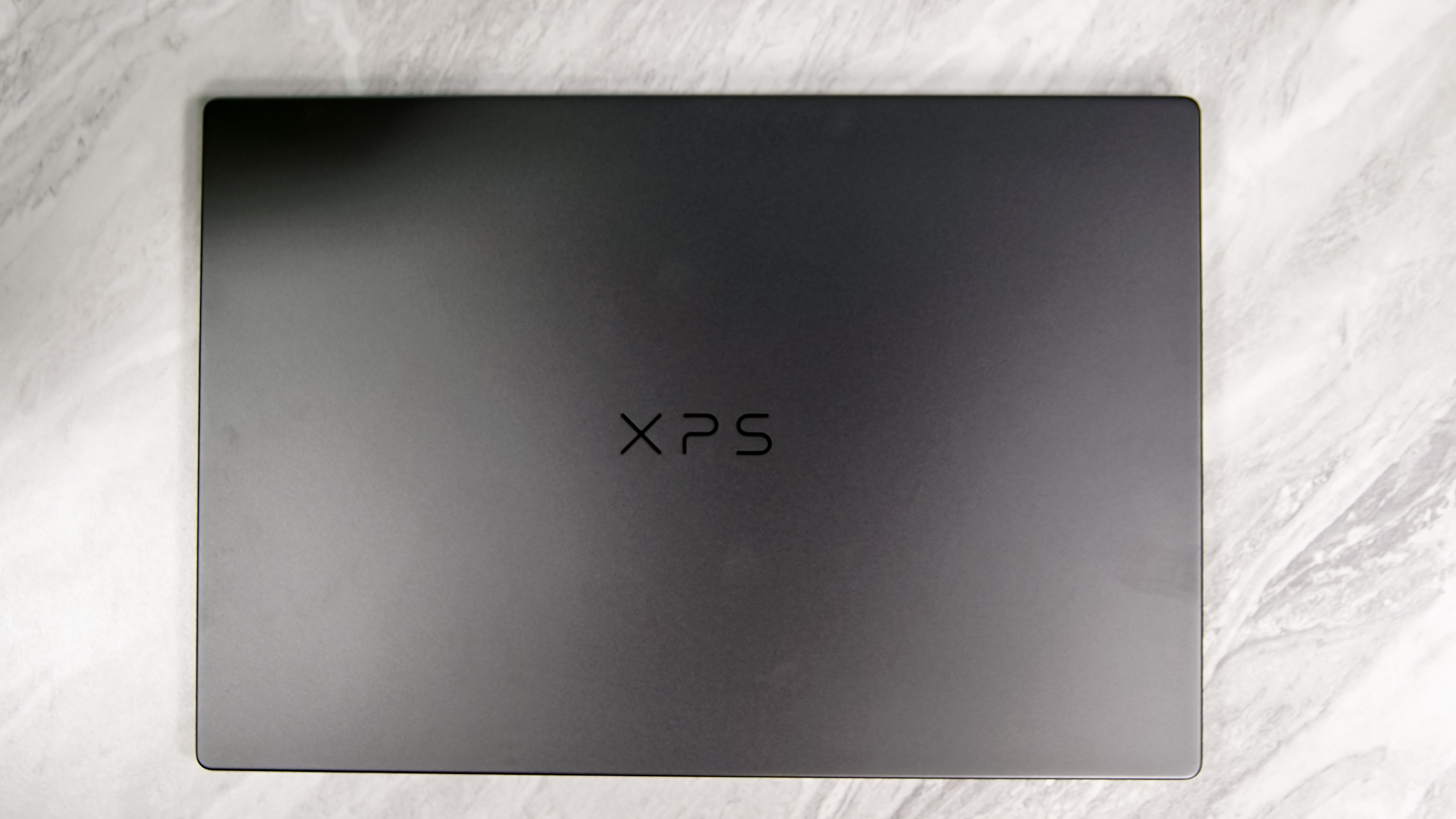 The Dell XPS 14 2026 shown from the side with the lid closed on a desk.