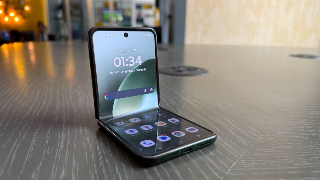 A front view of the Motorola Razr+ 2026 showcasing its large external display with a review headline overlay