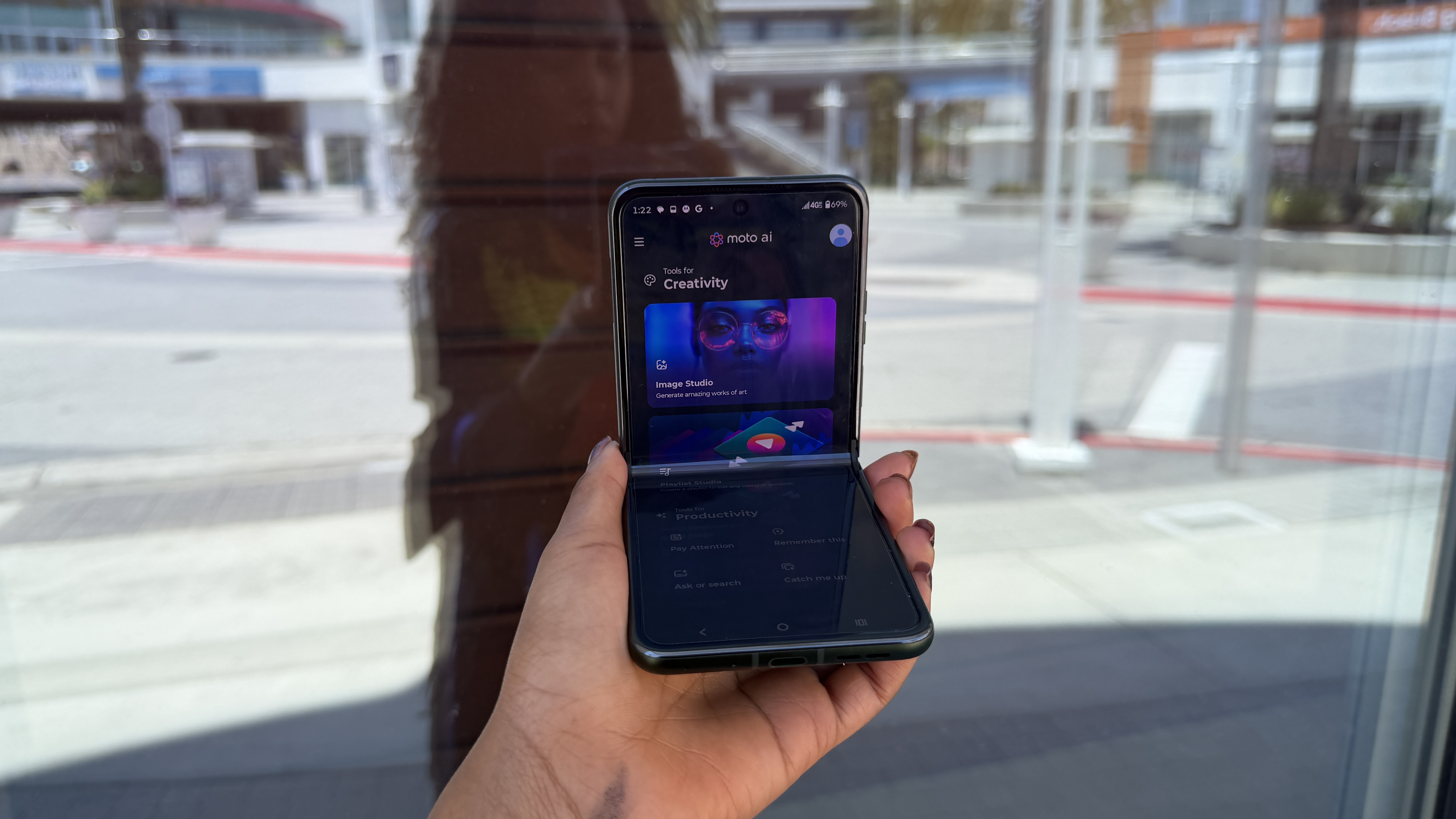 A woman holding the Motorola Razr+ showing an AI-powered lifestyle application on the screen