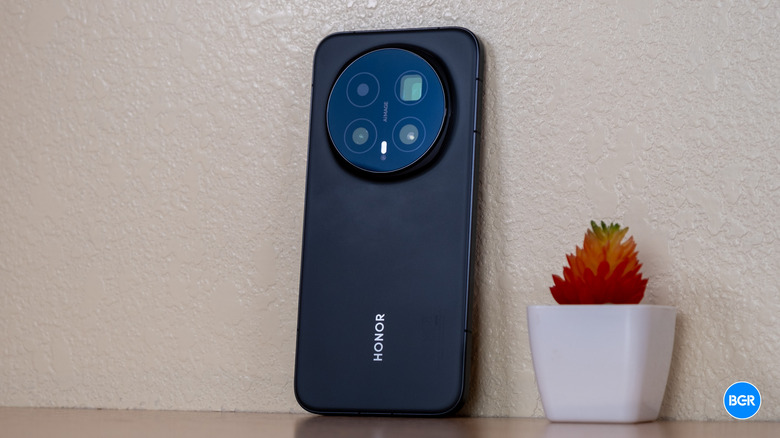 Honor Magic8 Pro smartphone leaning against a textured wall.