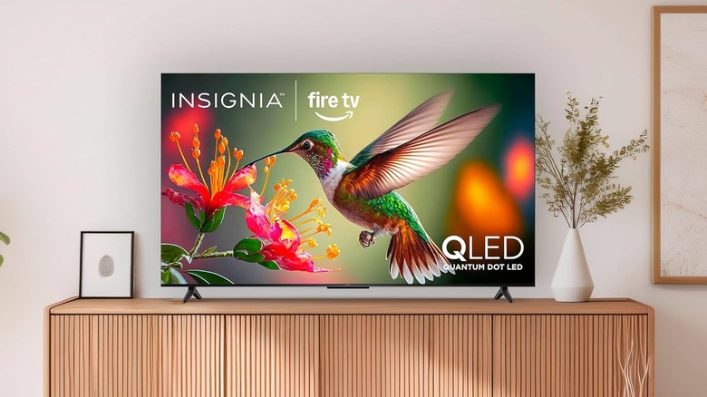An Insignia UQFL26 television positioned on a simple modern TV unit.