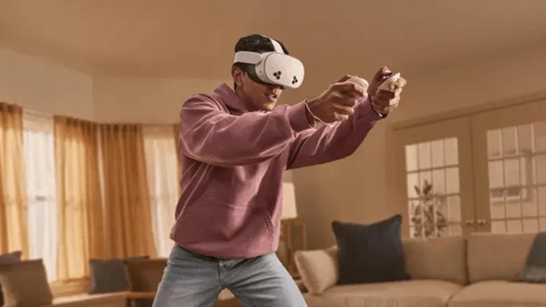 A person wearing a Meta Quest VR headset in a living room, demonstrating motion tracking.