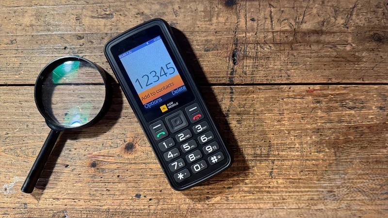 Rugged AGM M9 feature phone sitting on a wooden surface.