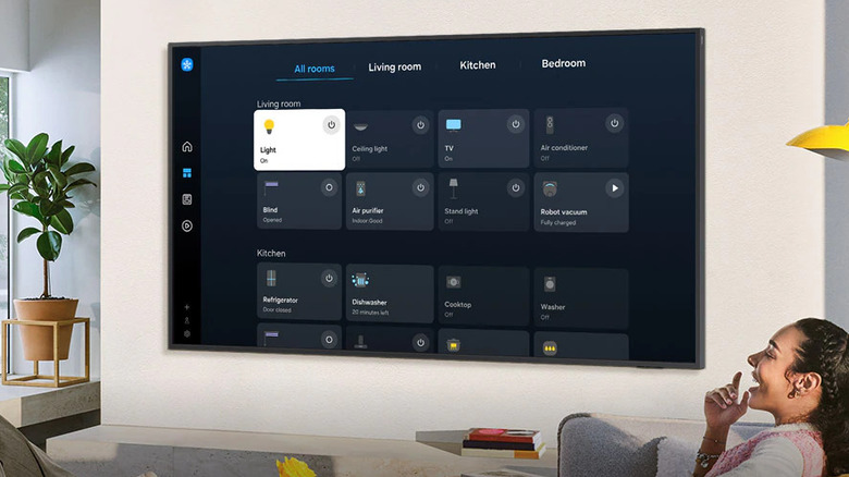 A smart TV screen showing the Samsung SmartThings menu with various connected device tiles.