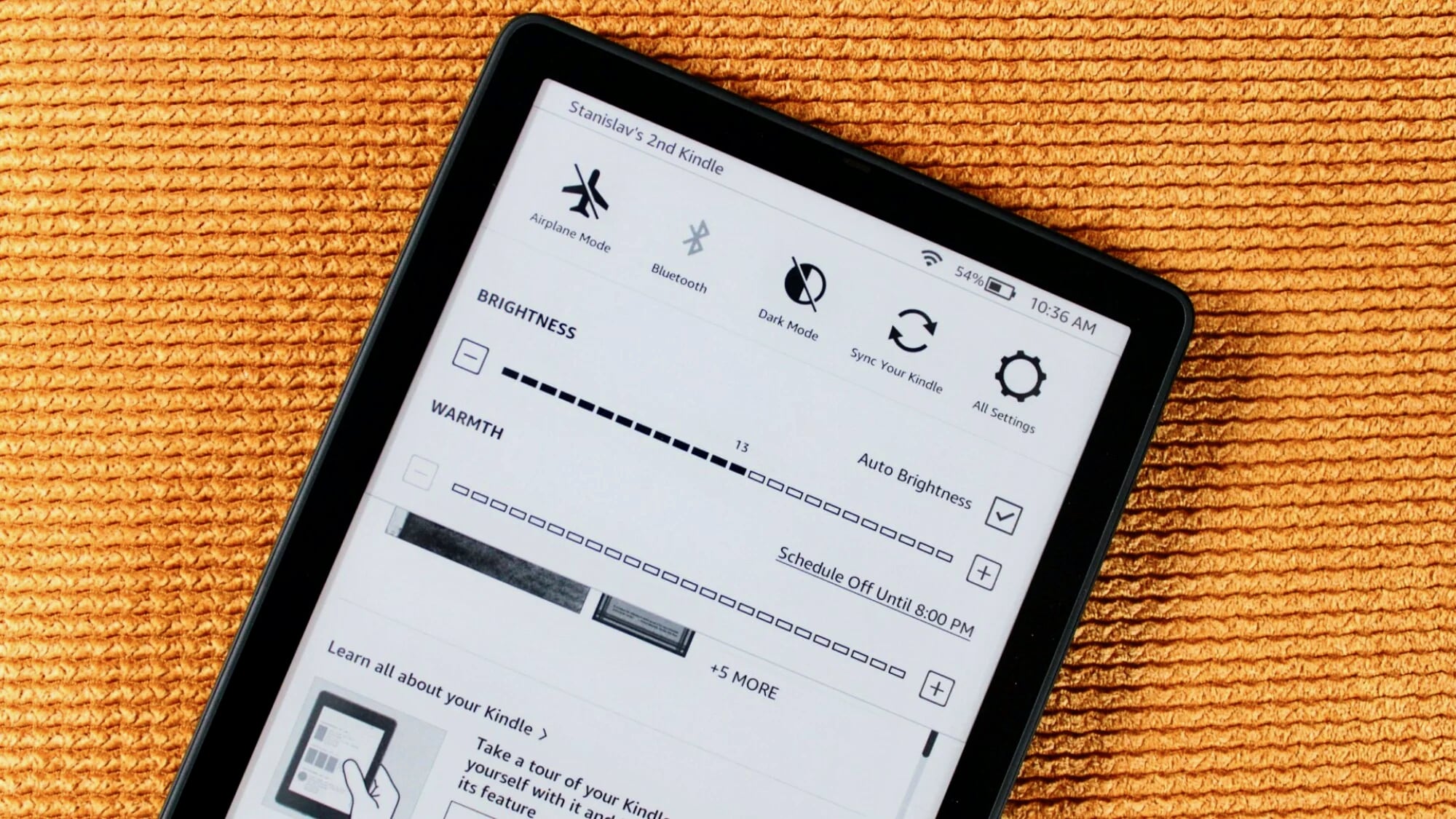 A close-up view of the Kindle settings menu showing brightness and warmth adjustment toggles.