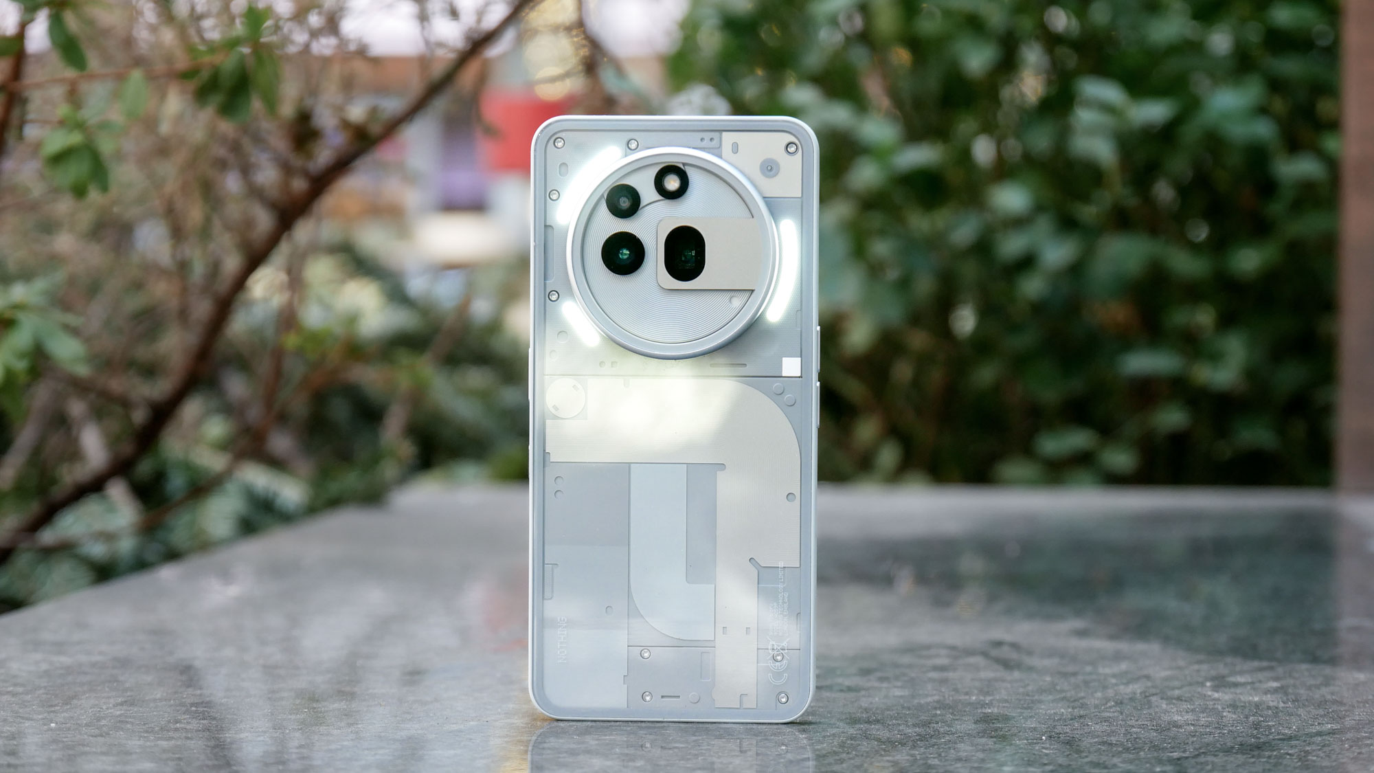 The back of a Nothing Phone 3a Pro showcasing its transparent design and camera setup.