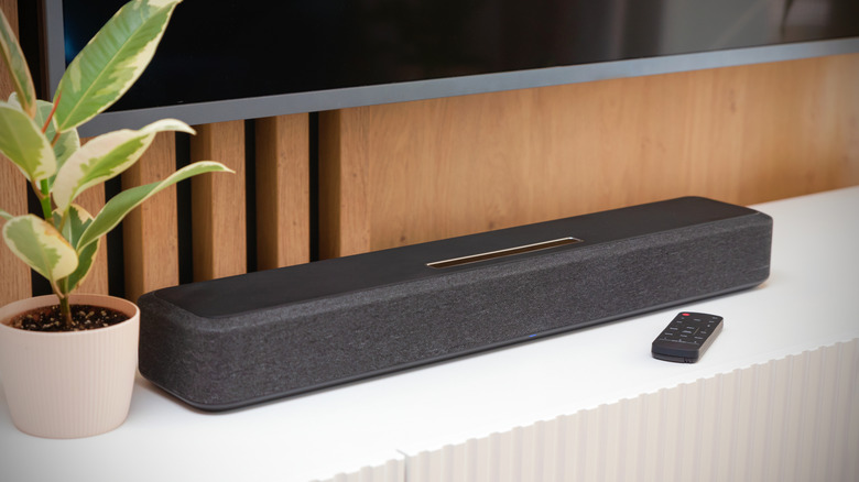 A sleek black soundbar positioned beneath a wall-mounted smart TV.