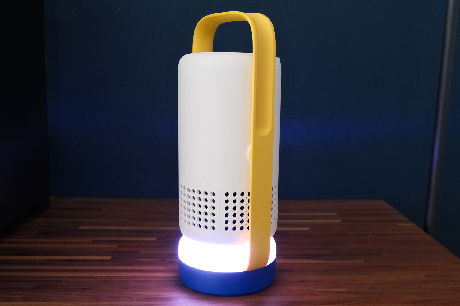 XGIMI Vibe One projector glowing with a purple ambient light in a dark room.