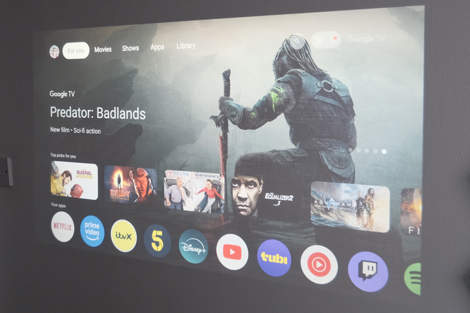 Projection of the Google TV home screen showcasing various apps like Netflix and YouTube.