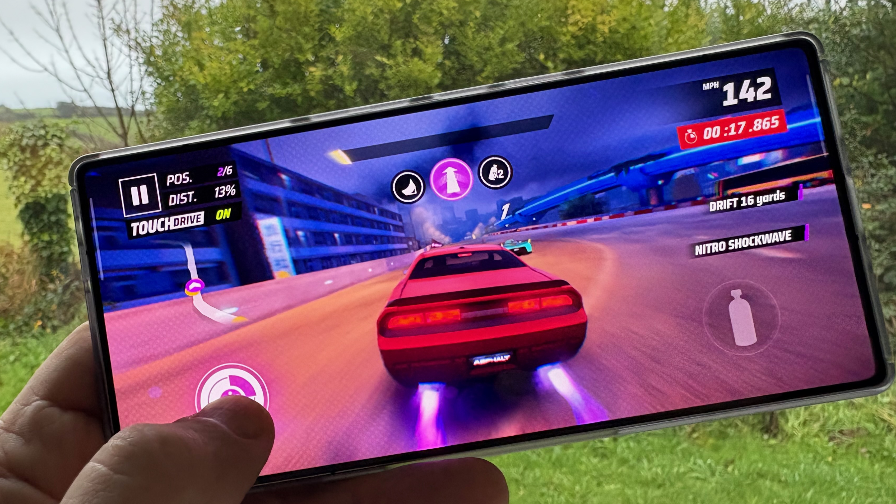 A handheld gaming phone showing an intense mobile action game being played on a high-refresh-rate screen.