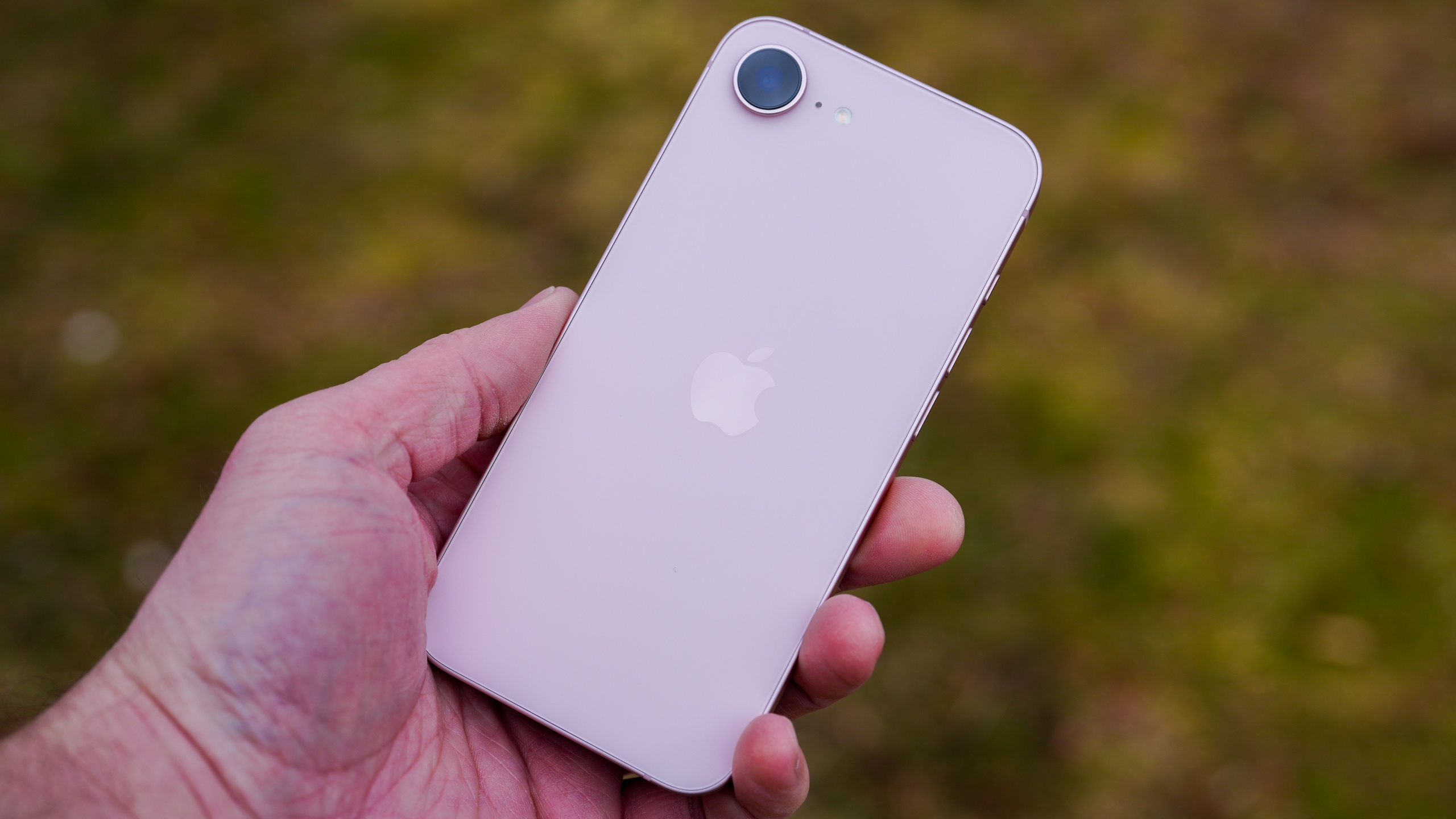 A person holding the 6.1-inch iPhone 17e to demonstrate its compact size.