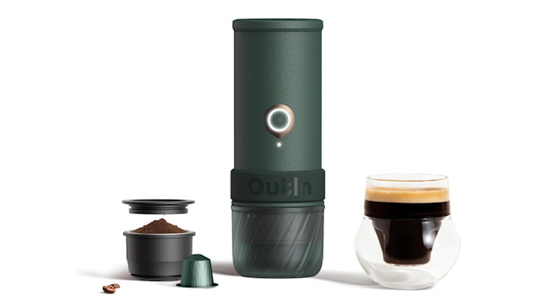 OutIn Mino Espresso Machine showing the coffee grinds and mug alongside the portable machine.