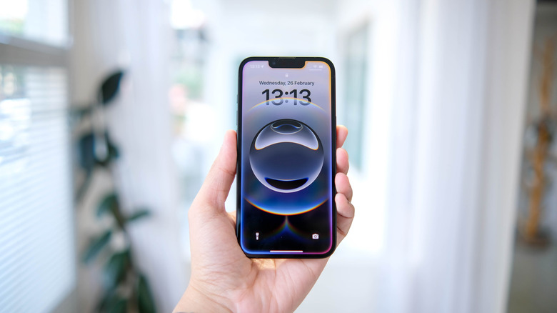 A hand holding the new iPhone 16e showing the refined camera module.